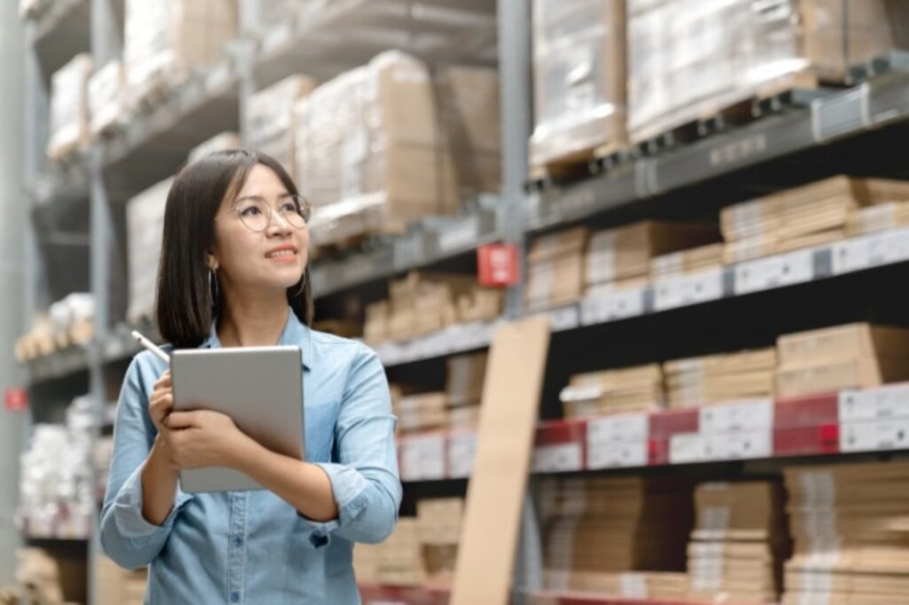 Supply chain: mulher em um estoque com tablet na mão.