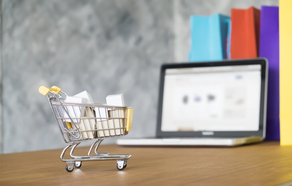 compras estratégicas: carrinho de compras em miniatura na frente de um computador