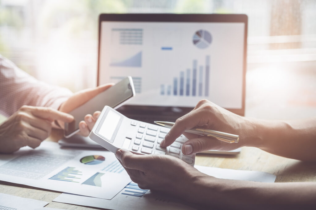 Análise do TCO: Mãos usando calculadora com dados ao fundo