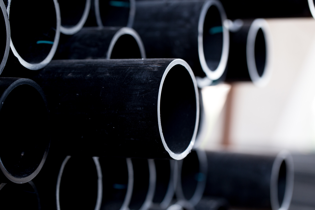 Na foto, vemos vários tubos de borracha preta PVC, sem ficar claro se são feitos de borracha natural ou borracha sintética.