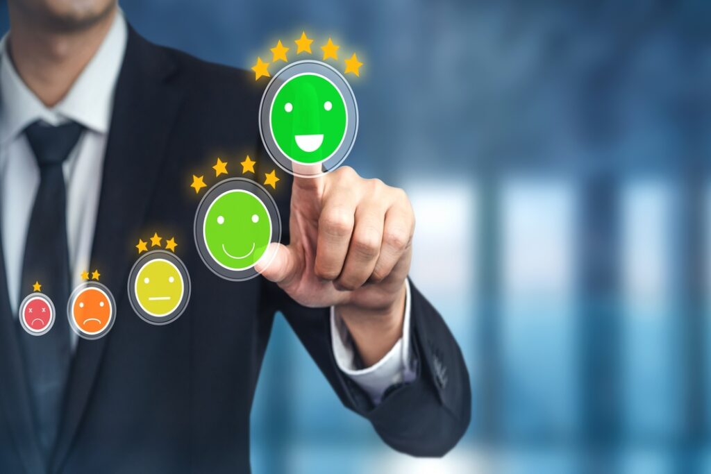 Imagem de um homem apontando para um desenho na tela com uma carinha verde sorridente que mostra bons indicadores de desempenho.